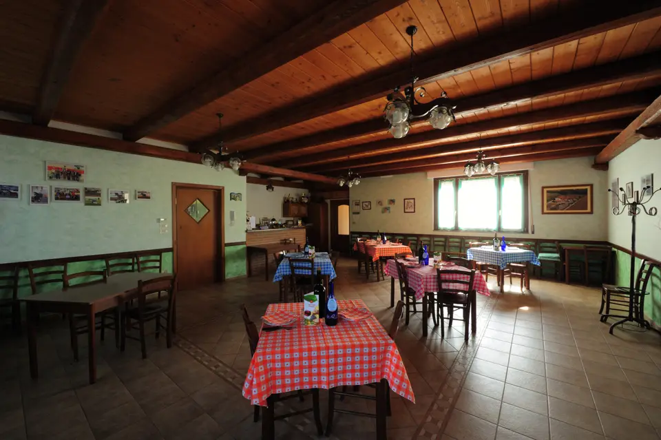 La sala da pranzo con soffitto in legno e tovaglie a quadri rossi